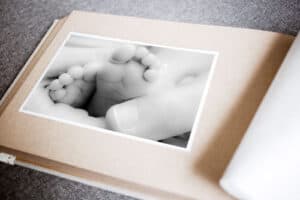 Detalles de un bebé en un álbum de fotos, en blanco y negro, destacando la ternura y la memoria familiar.