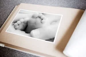 Detalles de un bebé en un álbum de fotos, en blanco y negro, destacando la ternura y la memoria familiar.