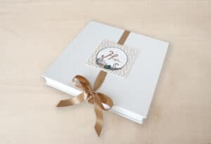 Álbum de fotos personalizado con lazo dorado y diseño elegante, ideal para recuerdos y momentos especiales.