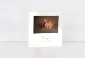 Adorable bebé durmiendo con gorro de lana en álbum de fotos personalizado.