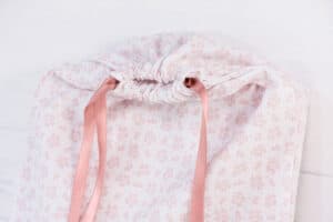 Bolsas de tela con diseño navideño y lazo de satén rosa para álbumes de fotos.