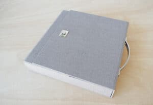Álbum de fotos en caja gris, elegante y duradero para guardar recuerdos.
