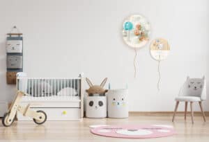 Dúo de globos con fotografías y nombres de bebé en habitación infantil decorada con estilo moderno.
