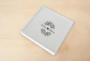 Álbum personalizado con diseño de hojas y nombres de pareja, ideal para recuerdos especiales.