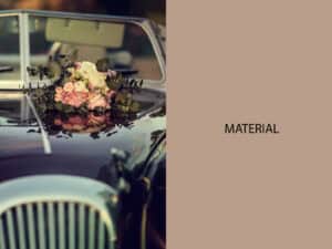 Boda vintage con ramo de flores rosas y verdes en coche clásico negro.