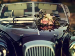 Decoración de coche clásico con ramo de flores para boda.